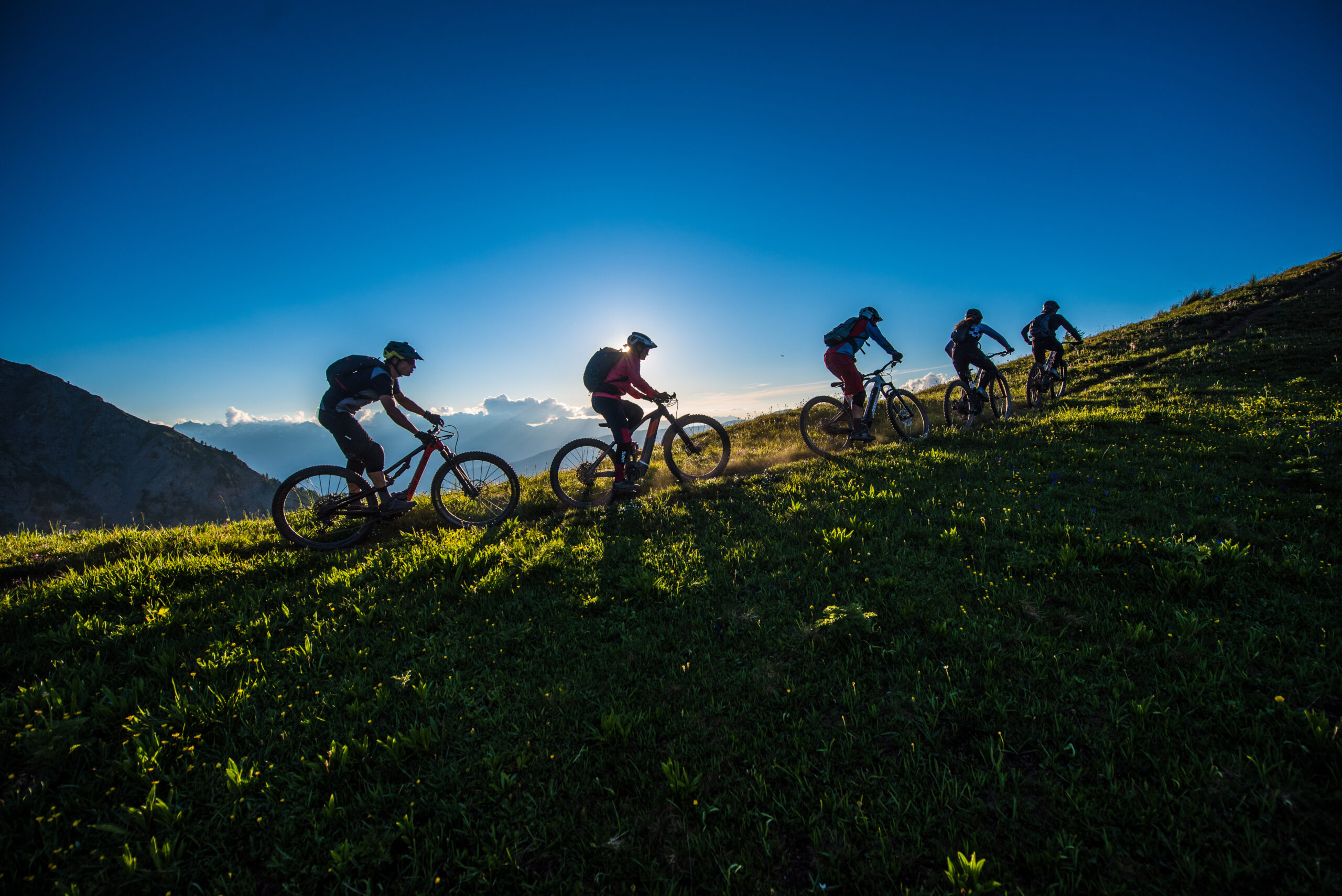 groupe de vététistes roulant sur une crête au coucher du soleil groupe de vététistes roulant sur une crête au coucher du soleil