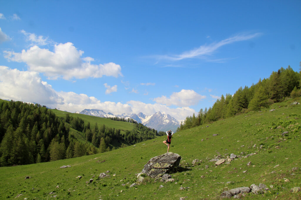 Personne faisant du yoga face à la montagne