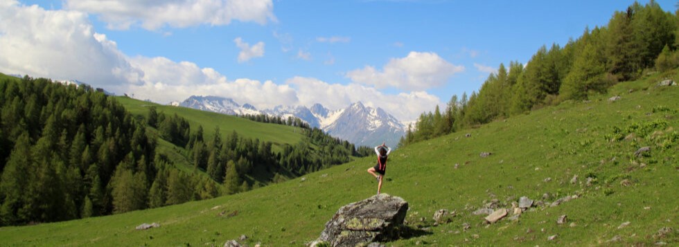 Personne faisant du yoga face à la montagne